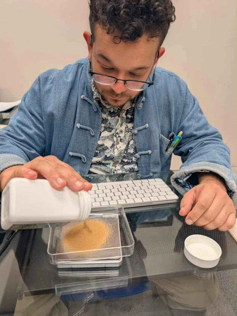 Glenn Braud carefully measuring 5:1 Chinese herbal granules to prepare a personalized formula at Big Easy Acupuncture in Metairie, LA.