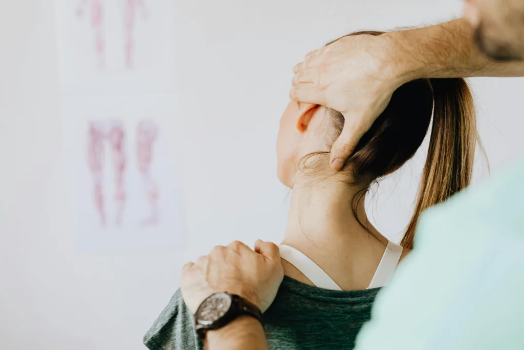 Practitioner performing manual therapy on a patient's neck to improve movement and reduce pain at Big Easy Acupuncture in Metairie, LA.