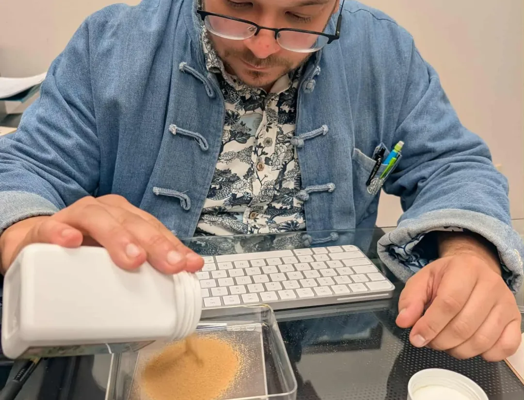 Glenn Braud carefully measuring 5:1 Chinese herbal granules to prepare a personalized formula at Big Easy Acupuncture in Metairie, LA.